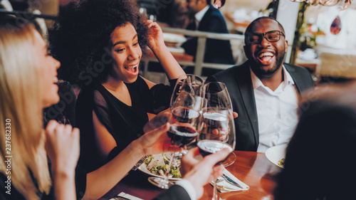 Group of Happy Friends Meeting and Having Dinner