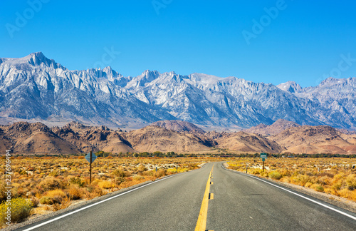 Empty road near Lone Pine with rocks of the Alabama Hills and the Sierra Nevada in the background, Inyo County, California, United States.