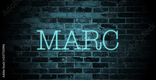 first name Marc in blue neon on brick wall
