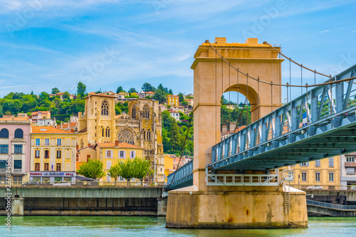 Cathedral in Vienne viewed behind a pedestrian bridge over river Rhone, France