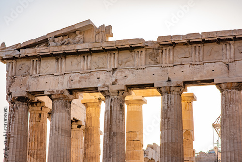 Close up of the top of functional doric columns, on the ancient Parthenon Temple of Athena, during sunset, at the Acropolis in Athens, Greece.