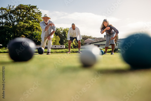 Senior people playing boules in a park