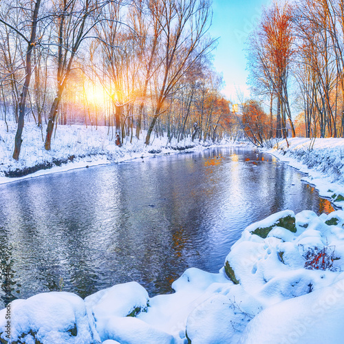 Winter landscape by a river in the sunset.