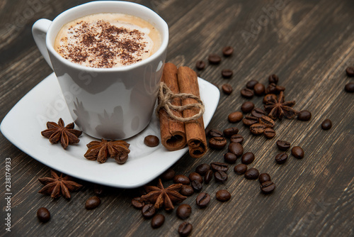 Espresso on wooden background. With coffee beans, cinnamon, star anise