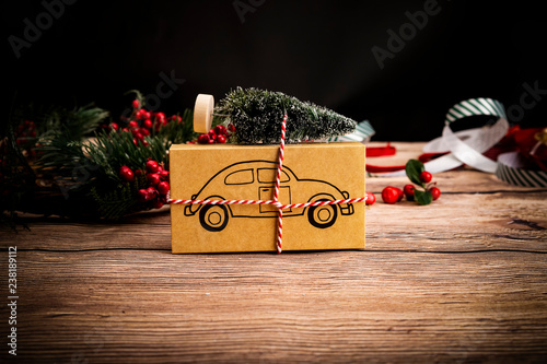 Samochód pod choinkę prezent . Świąteczny prezent z symbolem samochodu na drewnianym stole, kompozycja z miejscem na tekst.