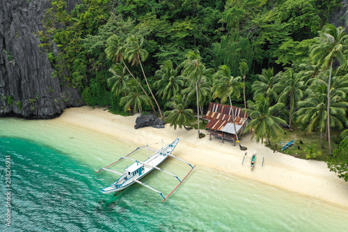 Aerial drone view of turquoise coastal waters and limestone cliffs in El Nido archipelago tourist destination. El Nido, Palawan, Philippines.