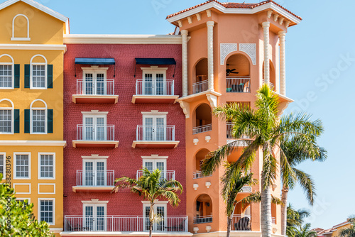 Florida condo, condominium colorful, red and orange multicolored buildings facade exterior with windows, palm trees, real estate property in Spain