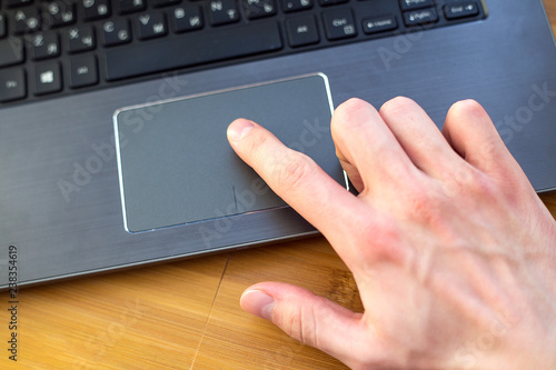 male index finger on a laptop trackpad