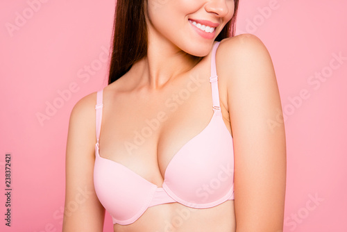 Cropped close up portrait of beautiful attractive gorgeous cute her she girl enjoying flawless perfect proportions decollete zone in pale pink bra isolated on pink background