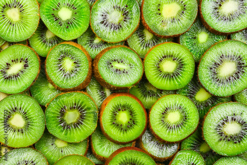 Top view of heap of sliced kiwi as textured background.