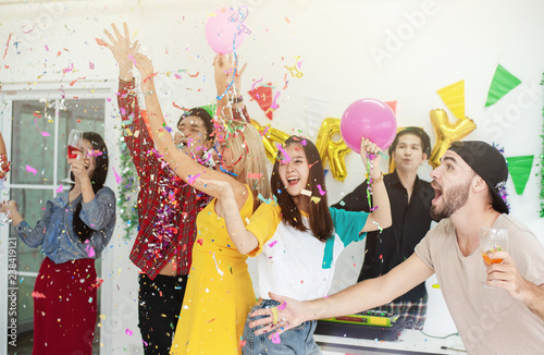Group of Multiethnic Friends Celebrating Chrismas New Year Party , Enjoy Throwing and Blowing Confetti Happy Time in Holiday
