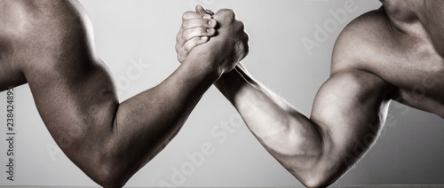 Two men arm wrestling. Rivalry, closeup of male arm wrestling. Two hands. Men measuring forces, arms. Hand wrestling, compete. Hands or arms of man. Muscular hand. Arm wrestling. Black and white.
