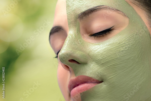 Woman having cosmetic facial seaweed treatment in spa.