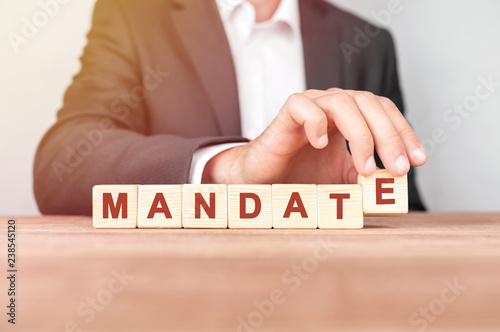 Man made word MANDATE with wood blocks