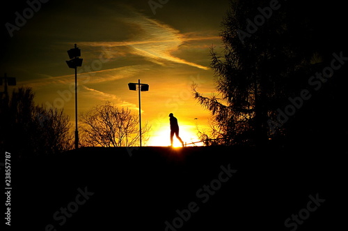 A weary wanderer against the background of the setting sun