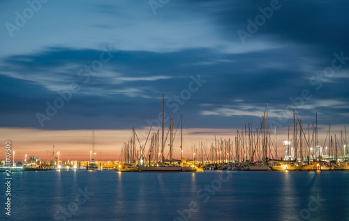 Yacht harbor of Cuxhaven Germany at sunset with water reflections.