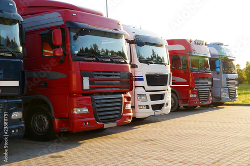 Transportation. Several trucks lined up in a row on a parking lot.