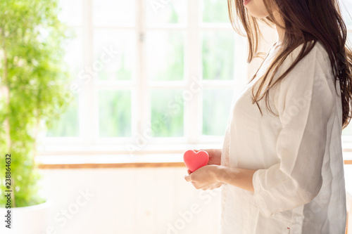 young asian woman holding heart symbol