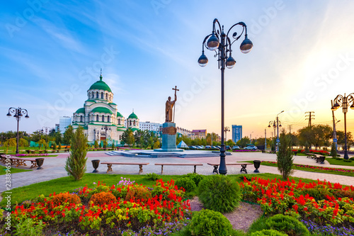 Beautiful colorful square in front of the Christian church in the city center during sunset with blue yellow sky. Monument to Saint Vladimir the Baptist and Vladimir Cathedral, Astrakhan, Russia.