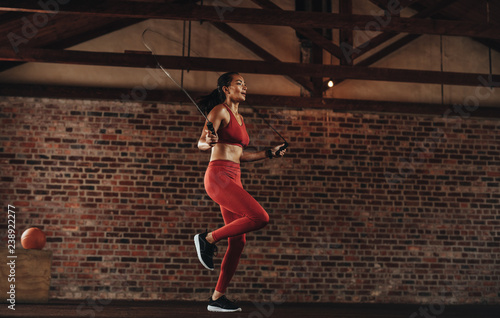 Healthy woman skipping rope at gym