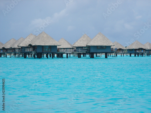 Overwater bungalow in beautiful blue ocean in Bora Bora, Tahiti
