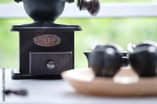 Coffee mill bean machine with coffee beans and cup at Cafe.