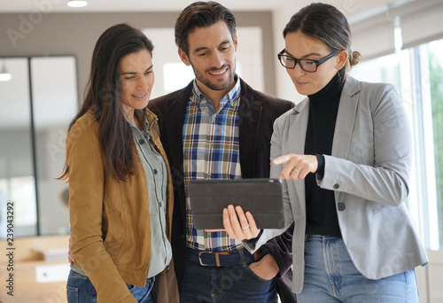 Real estate agent showing modern house to attractive couple