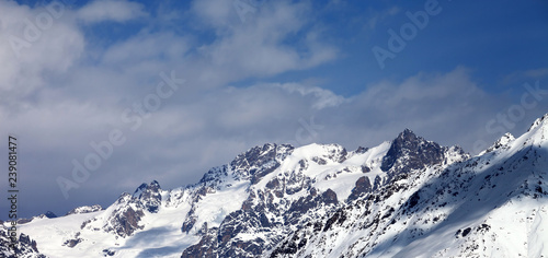 View on snowy mountains with glacier and cloudy blue sky