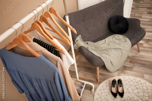 Wardrobe rack with female clothes in stylish dressing room