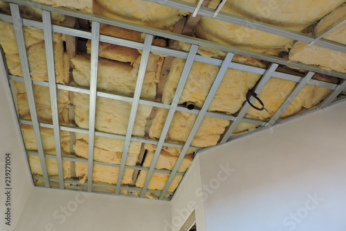 A metal frame of a ceiling under construction insulated with mineral wool 