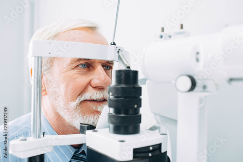 Senior patient receiving eye exam at clinic, eyesight examination aged people