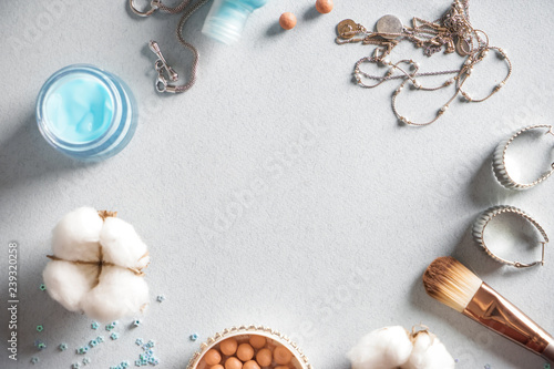 Frame made of cosmetic products and jewelry on light background
