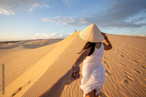 back view of Asian Woman travel with hat looking at White Sand dunes Mui ne, in Vietnam