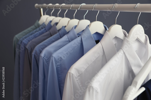 Wardrobe rack with men's clothes on grey background, closeup