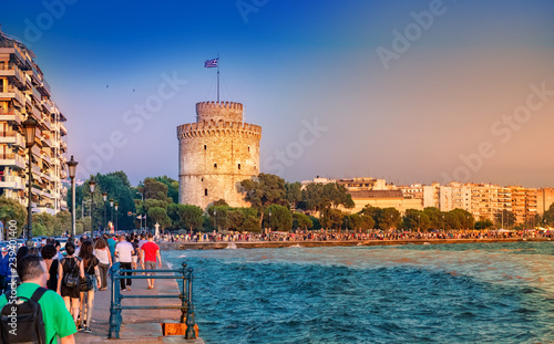 Colorful sunset over the city Thessaloniki in summer holiday, with tourists walking toward the center of town, in Greece