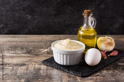 Aioli sauce and ingredients on wooden table. Copyspace