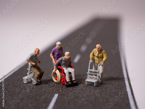 Senioren mit Rollstuhl und Rollator stehe auf de Strasse