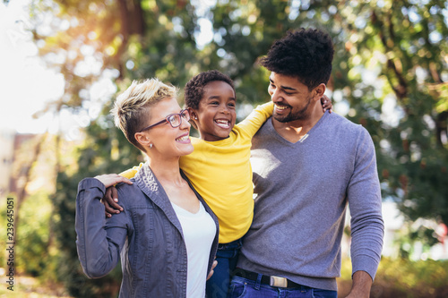 Happy young mixed race couple spending time with their daughter having fun