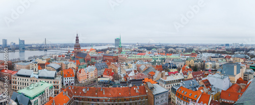 Aerial panoramic view of the Riga old town during winter day. Snowing in Riga. Top view of Dome Cathedral, statue of liberty, Daugava river and national library. Panorama