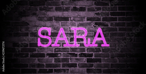 first name Sara in pink neon on brick wall