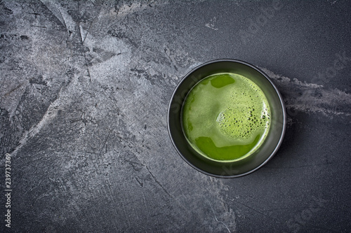 Top view on organic green matcha tea in black ceramic cup