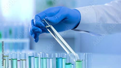 Lab worker taking test tube watching changes in substance, scientific experiment