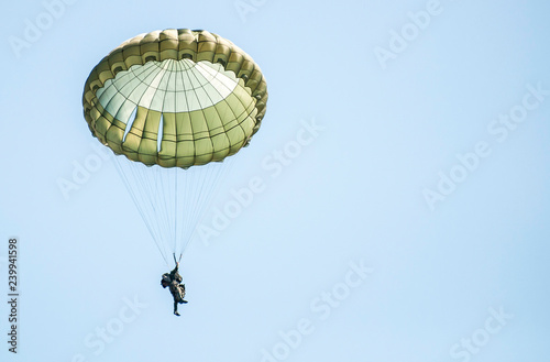 Many soldiers with parachutes in the sky.