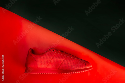 Buty sportowe. Kompozycja czerwonych butów na czerwonym tle.