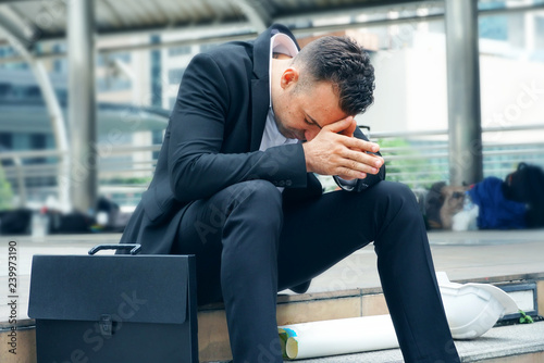 Businessman sit on the stairs and feel stressed