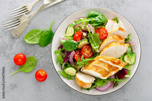 Grilled chicken breast, fillet and fresh vegetable salad of lettuce, arugula, spinach, cucumber and tomato. Healthy lunch menu. Diet food. Top view