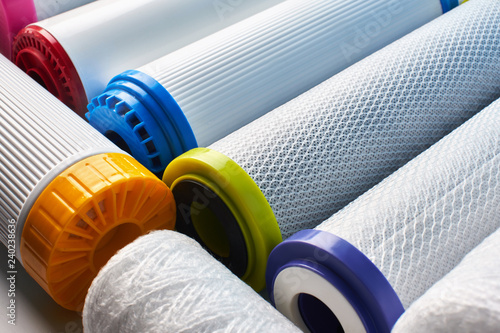 Water filters. Carbon cartridges on a white blue background close up. Household filtration system.