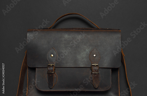 Fashionable concept. Brown leather men's bag on black background top view flat lay with copy space. Briefcase for work, Accessories businessman, stylish men's clothes, business background.