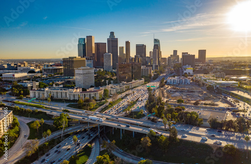 Drone view of downtown Los Angeles or LA skyline with skyscrapers and freeway traffic below.