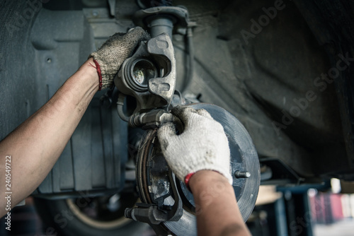 Car mechanics are changing brake pads in the garage.